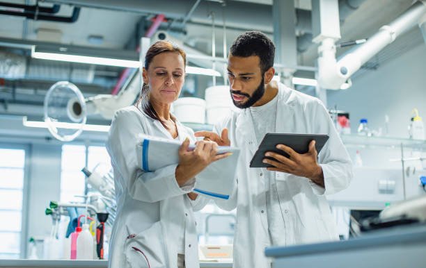 Two scientists reviewing data on a tablet in a modern laboratory